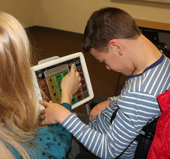 student clinician works with a client from the Barkley Speech Language and Hearing Clinic who uses an AAC device